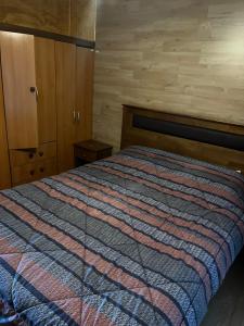 a bedroom with a bed with a striped blanket at Casa Amayita in Puerto Varas