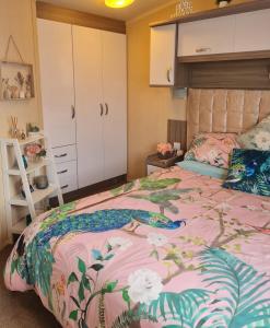 une chambre avec un lit rose à fleurs dans l'établissement Andreas Westfield Retreat 7 Lakes Country Park, à Crowle