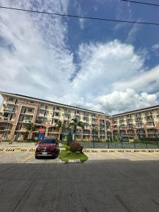 a car parked in front of a large building at D'living Condotel in Davao City