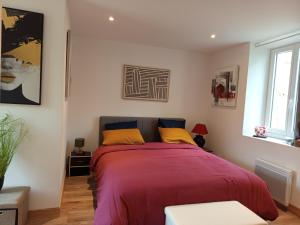 a bedroom with a bed with red blanket and yellow pillows at Résidence des 4 saison in Cransac +91 photos
