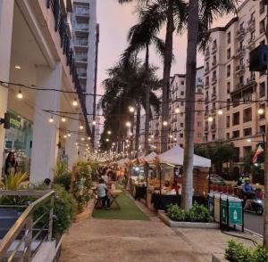 uma rua com palmeiras e pessoas sentadas às mesas em Telly's Studio Across NAIA3 em Manilla