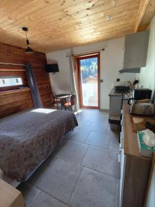 ein Schlafzimmer mit Bett und eine Küche mit Tisch in der Unterkunft Studio Sainte Marie in Lanslebourg-Mont-Cenis