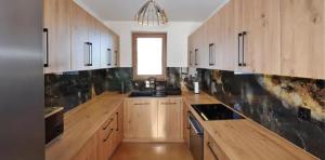 a large kitchen with wooden cabinets and a window at Dom pod Tatrami - Brzegi - Bukowina Tatrzańska in Brzegi