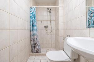 a bathroom with a shower with a toilet and a sink at Old Town - Best Location Apartment in Tallinn +7 photos