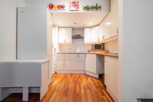 a kitchen with white cabinets and wooden floors at Old Town - Best Location Apartment in Tallinn