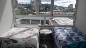 a bedroom with a bed and a large window at Departamento 610 in Temuco