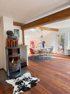 a living room with a wood stove and a table at Soleils Living I See & Berge I Starnberger See in Berg am Starnberger See