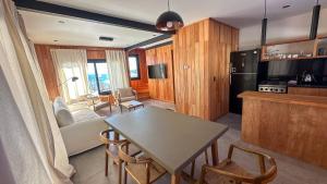 a kitchen and living room with a table and chairs at Vandor in San Martín de los Andes