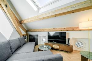 ein Wohnzimmer mit Sofa und Fernseher in der Unterkunft Appartement Original cœur de ville -AC- in Nizza