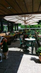 d'une terrasse avec des tables, des chaises et un parasol. dans l'établissement Hotel-Restaurant Jägerhof, à Unterreichenbach
