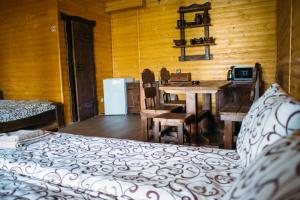 a bedroom with a bed and a table and a kitchen at Zarichna in Drogobych