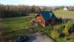 een bovenaanzicht van een blokhut met een blauw dak bij Kraina kaszubska - dom z balią kąpielową in Stare Czaple