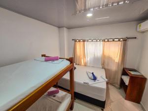 a small room with two beds and a window at Hotel Sueños Libres Necoclí in Necoclí