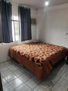 ein großes Bett in einem Zimmer mit Fenster in der Unterkunft Casa ampla e aconchegante in Foz do Iguaçu