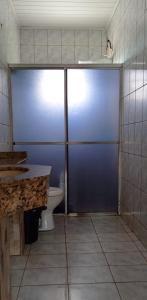 ein Badezimmer mit Toilette und blauer Schiebetür in der Unterkunft Casa ampla e aconchegante in Foz do Iguaçu