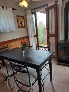 a dining room table with a vase of flowers on it at Pa-kuas del Uritorco in Capilla del Monte