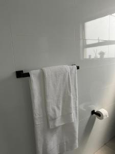 a white towel hanging on a towel rack in a bathroom at 2 Bedroom Condo in Sunninghill Sandton in Sandton +18 photos