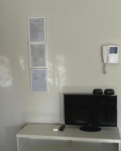 a white room with a table with a television at Residence Cà Mazzini in San Giorgio Di Mantova