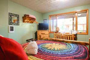 a bedroom with a bed and a television and a window at Timber Wolf Campground Resort & Jeep Rentals in Hungry Horse