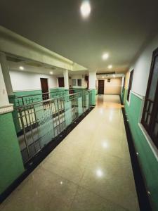 un pasillo vacío de un edificio con paredes verdes y blancas en Sathya Inn Guruvayur, en Trichūr