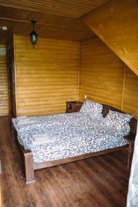 a bed in a room with a wooden wall at Zarichna in Drogobych +22 photos