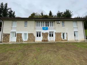 a large white building with a stone wall at Hotel Rural El Nuevo Semellon Aceptamos Mascotas in La Llama