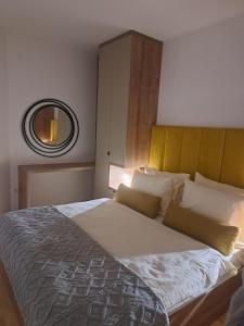 a bedroom with a large bed with a mirror at Diva apartman in Donje Mladice