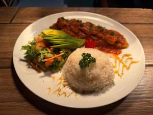 un plato de comida con arroz y verduras en una mesa en Hotel El Bambu, en Sarapiquí 16 fotos más