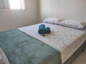 una cama con un par de zapatos sentados en ella en Apartamento com suíte no bairro de Santa Monica, en Uberlândia