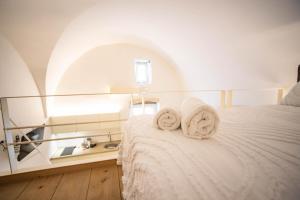 a bedroom with a bed with towels on it at Nivèra White Allure Maison in Ostuni