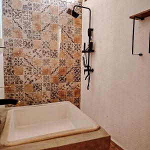 CabreraにあるHacienda Camino de Piedra San Miguel de Allendeのタイル張りの壁のバスルーム(バスタブ付)