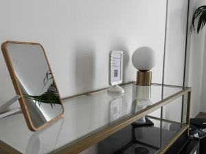 a glass table with a mirror on top of it at Serèsia Rooms Siracusa Centro in Syracuse
