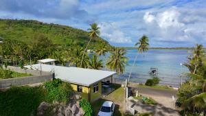 a yellow house on the shore of a body of water at O'Hani-Ura lodge in Bora Bora