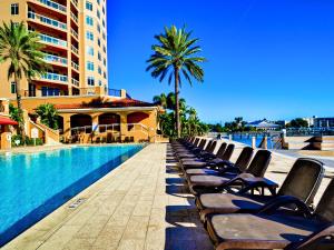 a row of chaise lounge chairs next to a swimming pool at Belle Harbor 401W in Clearwater Beach