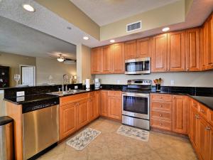 a kitchen with wooden cabinets and stainless steel appliances at Belle Harbor 401W in Clearwater Beach