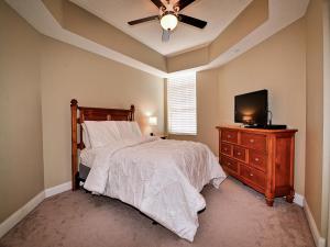 a bedroom with a bed with a ceiling fan and a television at Belle Harbor 401W in Clearwater Beach +21 photos