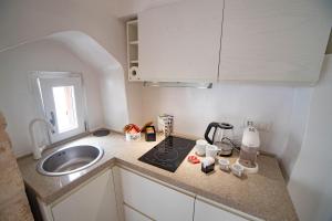 a small kitchen with a sink and a counter top at Nivèra White Allure Maison in Ostuni +37 photos