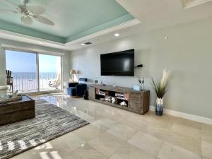 a living room with a flat screen tv on a wall at Chateaus on White Sands 302 in Clearwater Beach