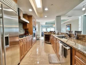 a large kitchen with wooden cabinets and stainless steel appliances at Chateaus on White Sands 302 in Clearwater Beach