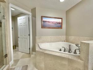 a bathroom with a tub with a picture on the wall at Chateaus on White Sands 302 in Clearwater Beach +24 photos