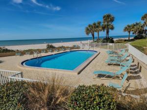 een zwembad met ligstoelen en het strand bij Sonrisa 11 in Clearwater Beach