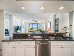 een keuken met witte kasten, een gootsteen en een raam bij Sonrisa 11 in Clearwater Beach