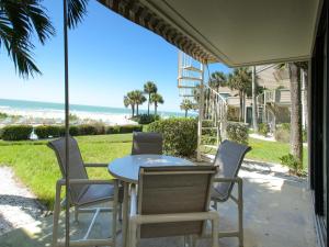 een terras met een tafel en stoelen en de oceaan bij Sonrisa 11 in Clearwater Beach