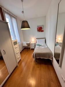 a small bedroom with a bed and a mirror at Appartamenti Portavenezia in Padova