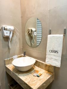 a bathroom with a sink and a mirror at Suítes Oásis in Macau
