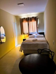a bedroom with a bed with a window and a table at Suítes Oásis in Macau +63 photos