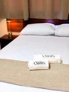 two towels on a bed in a hotel room at Suítes Oásis in Macau