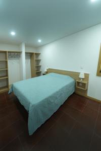 a bedroom with a bed with a green bedspread at Quintinha de Sá in Arnoso