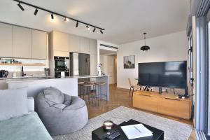 un soggiorno con divano e TV a schermo piatto di Luxe on the BEACH By LIME a Haifa
