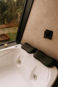 a white bathroom sink with a black bow tie on it at Cabana Catuaí in Espera Feliz